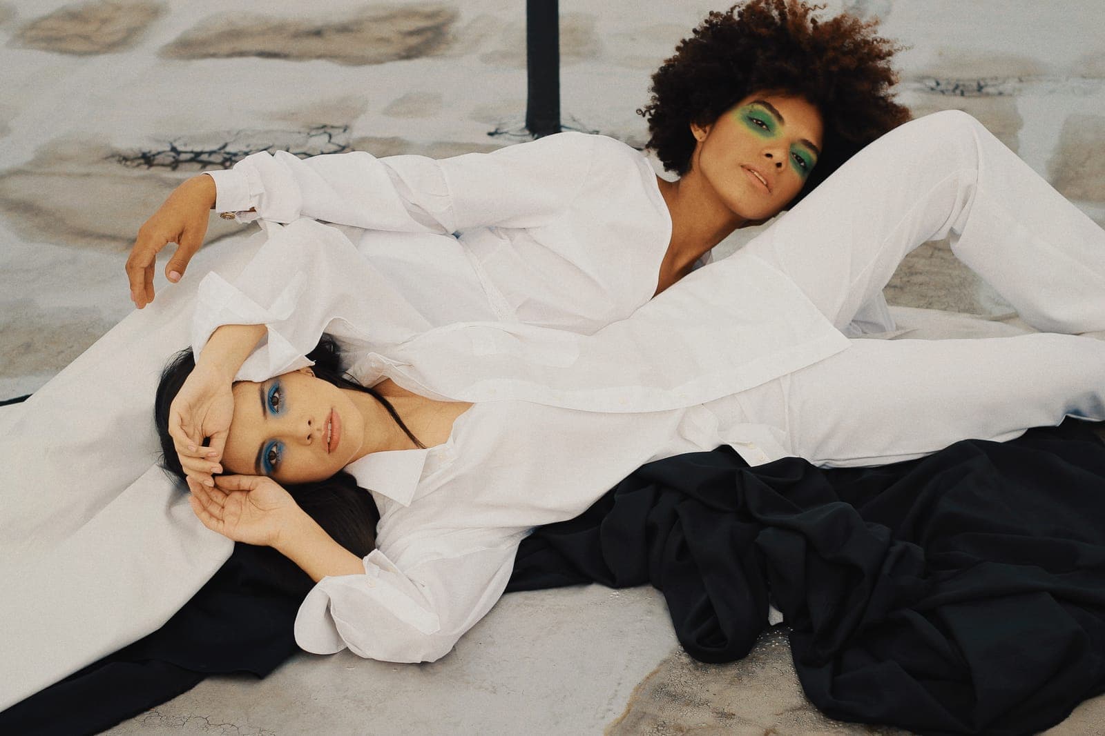 Two women in white suits lying on the floor